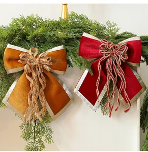 Detailed view of large red and gold velvet Christmas bow decorations with silver trim