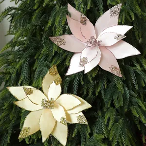 Schöne rosa und cremefarbene Weihnachtsblumen aus Samt mit Pailletten auf einem Baum