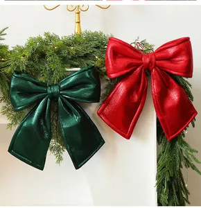Detailed view of red and green large Christmas bows with metallic finish on pine branches