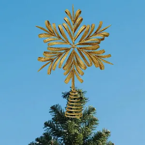 Elegant golden glittery iron hollow snowflake Christmas tree topper on green tree