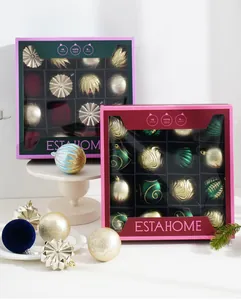 Gros plan de coffrets de boules de Noël festives en finitions rouge, vert et or.