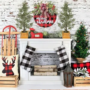 Pair of artificial cedar Christmas trees in wooden pots for holiday mantel decor.