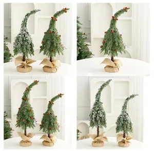 Detail view of miniature curved Christmas trees with snow flocking and burlap bases