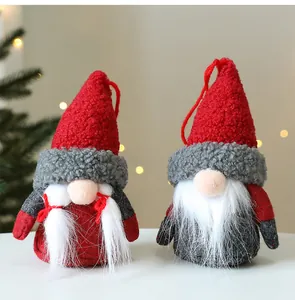 Vue détaillée de deux mignons gnomes de Noël en peluche avec bonnets rouges et barbes