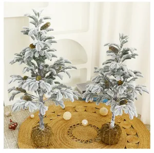 Detailweergave van twee besneeuwde ceder-kerstbomen met decoratieve mosbal-voeten