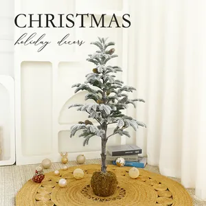 Besneeuwde kerstboom met dennenappels en mosbasis voor feestelijke decoratie.