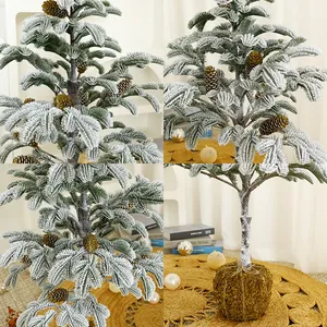 Handgemaakte mini besneeuwde kerstboom met natuurlijke dennenappels en groene mosbasis