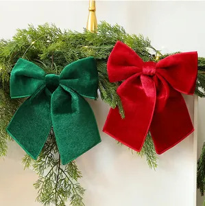 Detailed view of large red and green velvet Christmas bows on a festive green garland