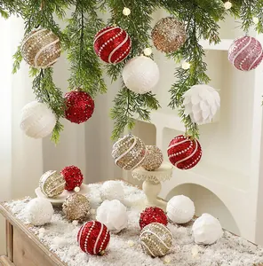 Detailed macro view of 8cm red, gold, and white glitter Christmas ornaments on a tree