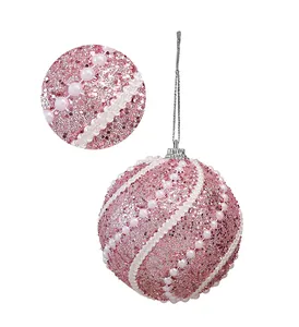 Close-up detail of a pink glitter Christmas ball ornament with white pearl accents