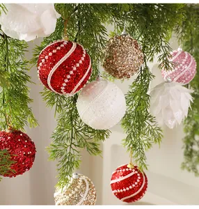Detailed macro shot of 8cm glittery Christmas balls with pearl accents on pine