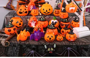 Diverse collection of glowing Halloween pumpkin lanterns and party decorations on a spiderweb cloth