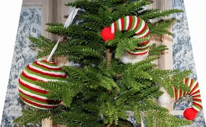 Detailed close-up of red and green striped knitted Christmas tree ball and elf hat ornaments