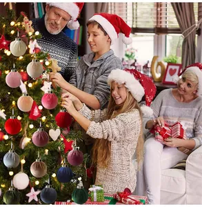 Gelukkig gezin dat de kerstboom versiert met diverse 6-8 cm fluwelen stoffen ballen