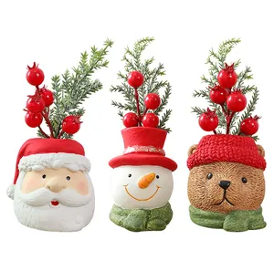 Detail of 3 Christmas resin figurines: Santa, Snowman, and Bear with festive pine branches.