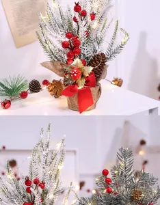 Close-up van besneeuwde mini-kerstboom met rode bessen en LED-verlichting