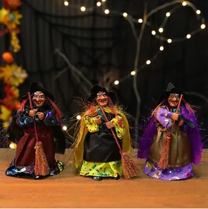 Un ensemble de trois figurines de sorcières d'Halloween avec balais dans un décor