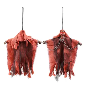 Détail d'un fantôme d'Halloween suspendu avec des yeux rouges brillants et du jute.