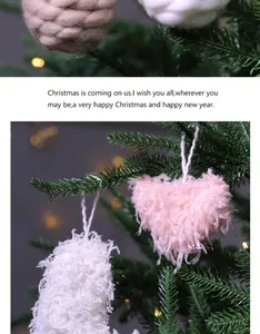 Primer plano de adornos de corazones peludos en rosa y blanco en un árbol de Navidad
