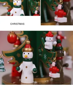 Close-up detail of a handcrafted wooden Christmas tree ornament with snowman figurines