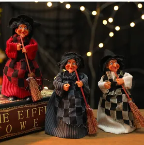 Vue détaillée de trois figurines de sorcières d'Halloween tenant des balais en tenue de fête