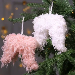 Elegantes adornos de árbol de Navidad con alas de corazón rosa y blanco en ramas verdes