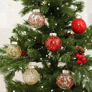 Elegant red and gold Christmas baubles set hanging on a festive snowy Christmas tree branch