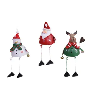 Set of three vintage metal Christmas ornaments featuring Santa, Snowman, and Reindeer