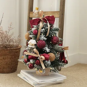 Elegant mini PE Christmas tree with warm LED lights, red bows, and festive ornaments for home decor