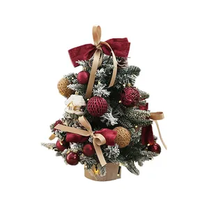Mini árbol de Navidad con nieve artificial, luces LED, lazos y adornos rojos.