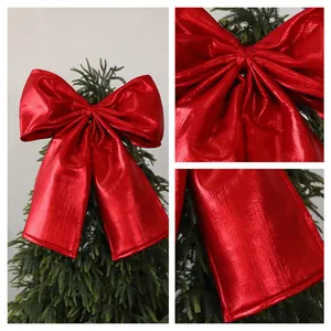 Close-up detail of a large metallic red velvet Christmas bow showing fabric texture