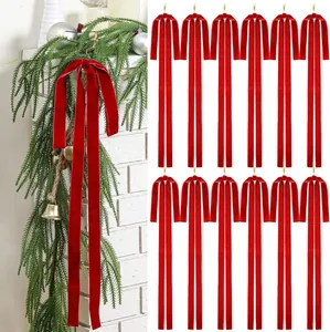 Set of red velvet Christmas bows hanging for festive tree and home decoration.