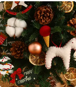 Primo piano di mini albero di Natale decorato con pigne, cotone e ornamenti vari.