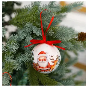 Vue détaillée d'une boule de Noël blanche ornée d'un Père Noël et d'un renne