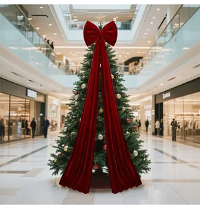 Large red velvet Christmas tree topper bow with long tails in a mall setting
