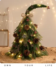 Dettaglio di un mini albero di Natale con punta curva, pigne e luci calde soffuse