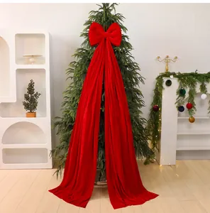 Detailed view of a large red velvet Christmas bow with long tails on a tree
