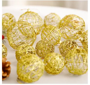 Vista dettagliata delle palline di Natale dorate e traforate con glitter festivi.