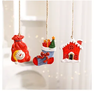 Detailed view of three resin Christmas ornaments hanging by jute strings in a cozy room.