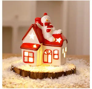 Charming glowing Nordic ceramic Christmas house with snowman detail for holiday decor