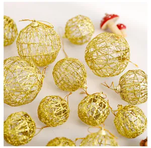 Vista ravvicinata di palline di Natale dorate traforate con glitter per decoro festivo