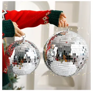 Nahaufnahme von silbernen Spiegel-Discokugeln in zwei Größen mit festlichem Weihnachtspulli