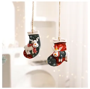 Detailed view of two hanging resin Christmas sock ornaments featuring cute reindeer figures