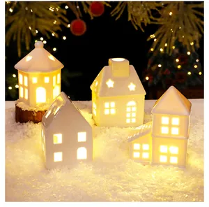 Warm glowing Nordic ceramic house miniatures set in a cozy snowy Christmas scene.