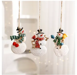 Detail view of three resin snowman ornaments with colorful scarves and hemp ropes.
