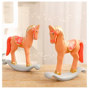 Primer plano de dos figuras decorativas de caballitos balancines de Navidad