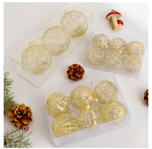 Dettaglio di palline di Natale glitterate oro in scatole trasparenti con pigne decorative