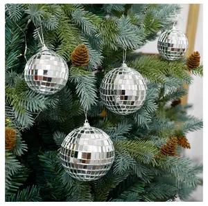Detailansicht von silbernen Spiegel-Discokugeln an einem grünen festlichen Tannenbaum