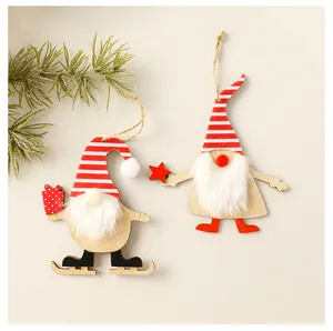 Close-up of two wooden Christmas gnome ornaments with red striped hats and fluffy beards