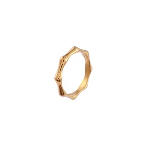 Gros plan détaillé d'une bague dorée minimaliste de style bambou avec finition brillante.